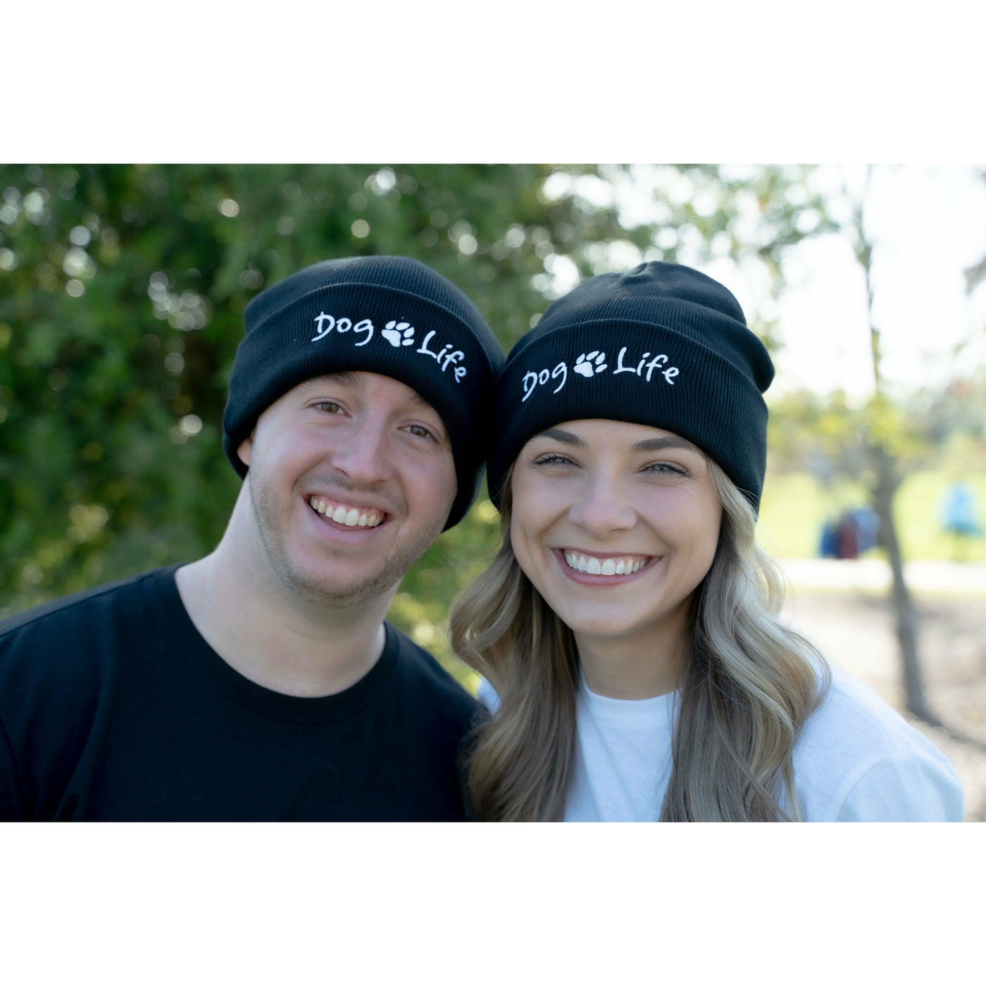 Smiling young man and woman wearing Dog Life beanies.  Dog Life apparel